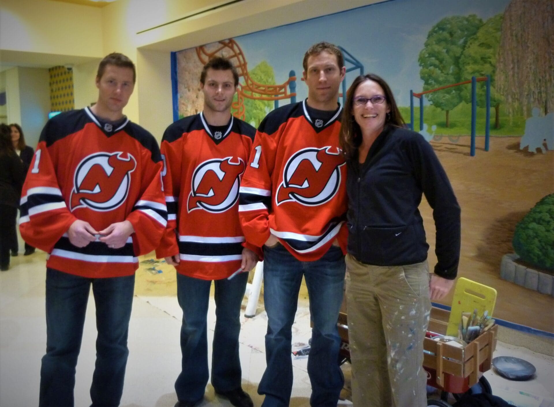 Three Men in Orange Jersey Along With a Woman in Black Shirts