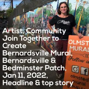 A Woman Holding an Orange Signage Infront of a Mural